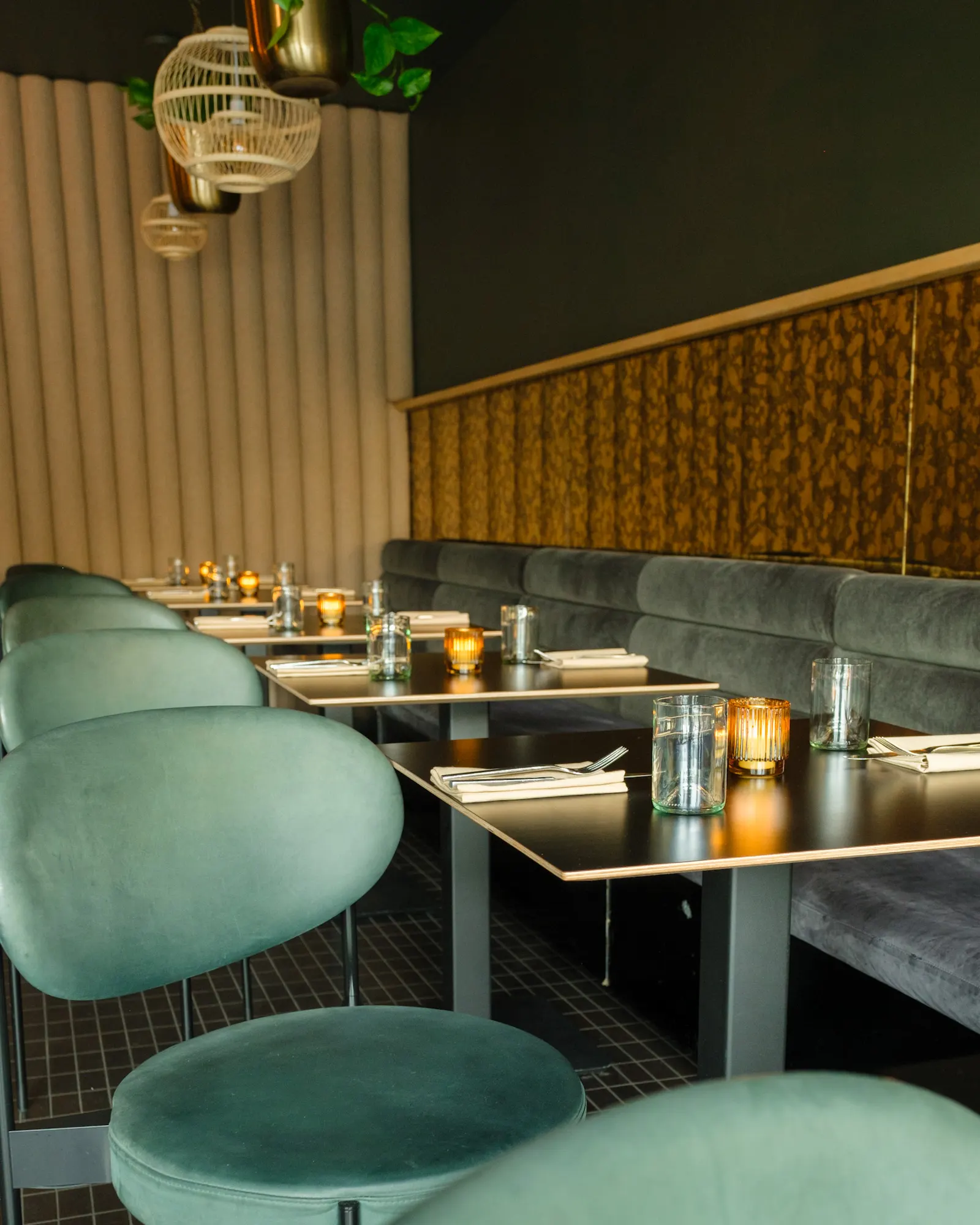 Velvet chairs against a gold-textured wall.