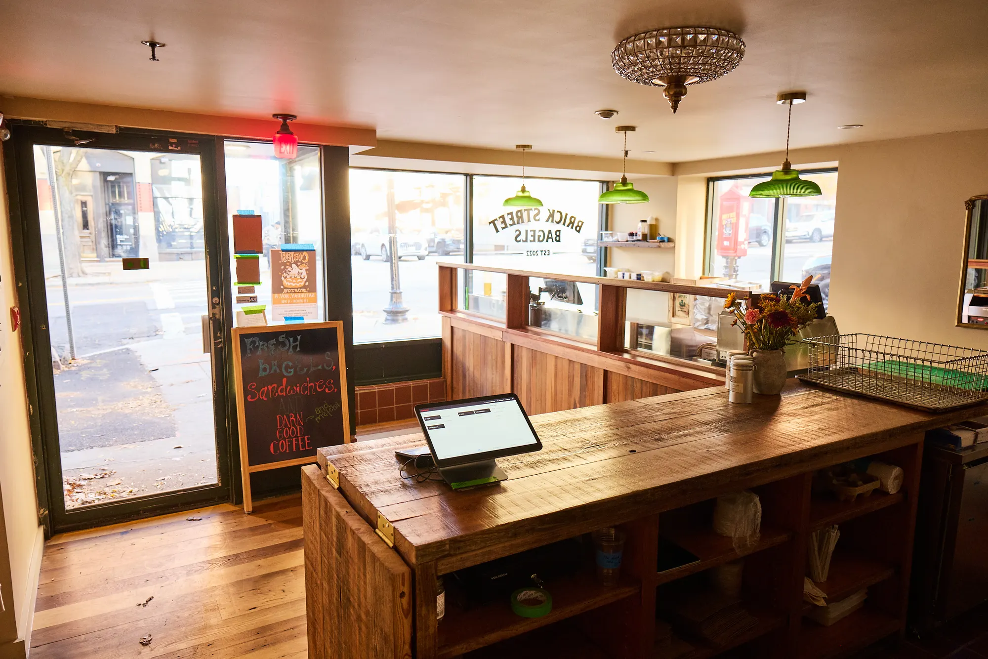 The ordering counter and its till beside the glass door, with the signed front windows beyond.
