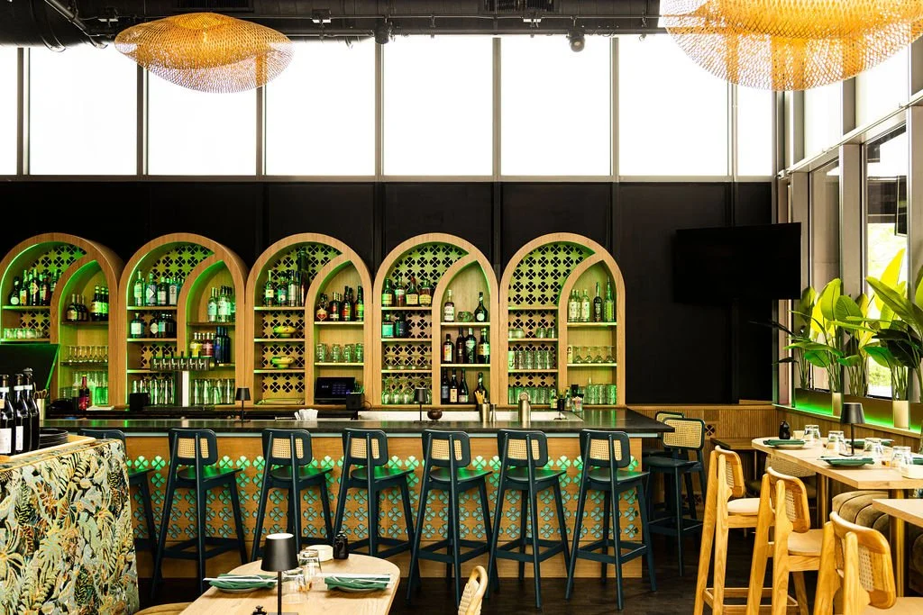 Five timber arches over the bar, each lined and lit in green.