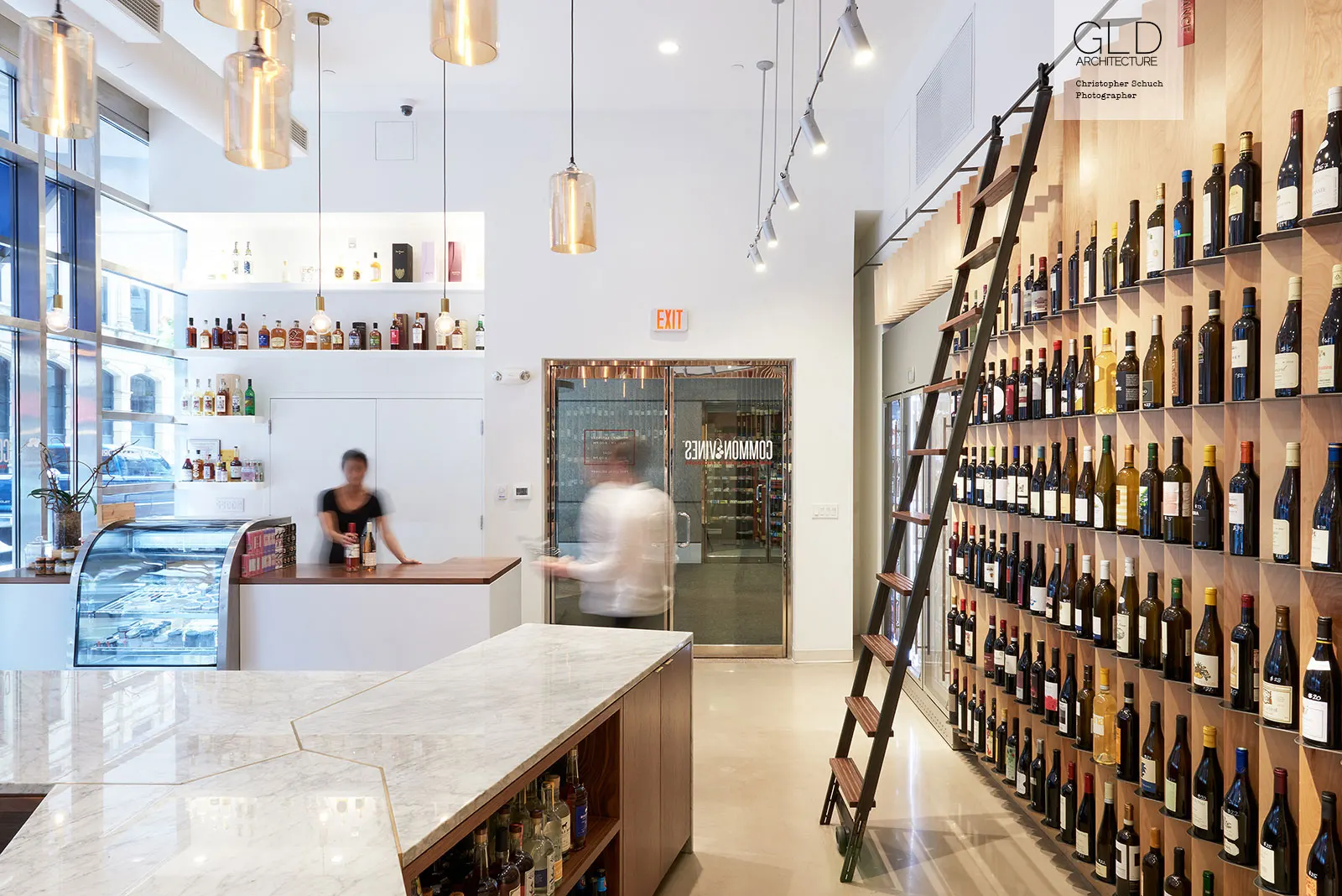 The shop at Common Vines, a curved wall of bottles beside the counter