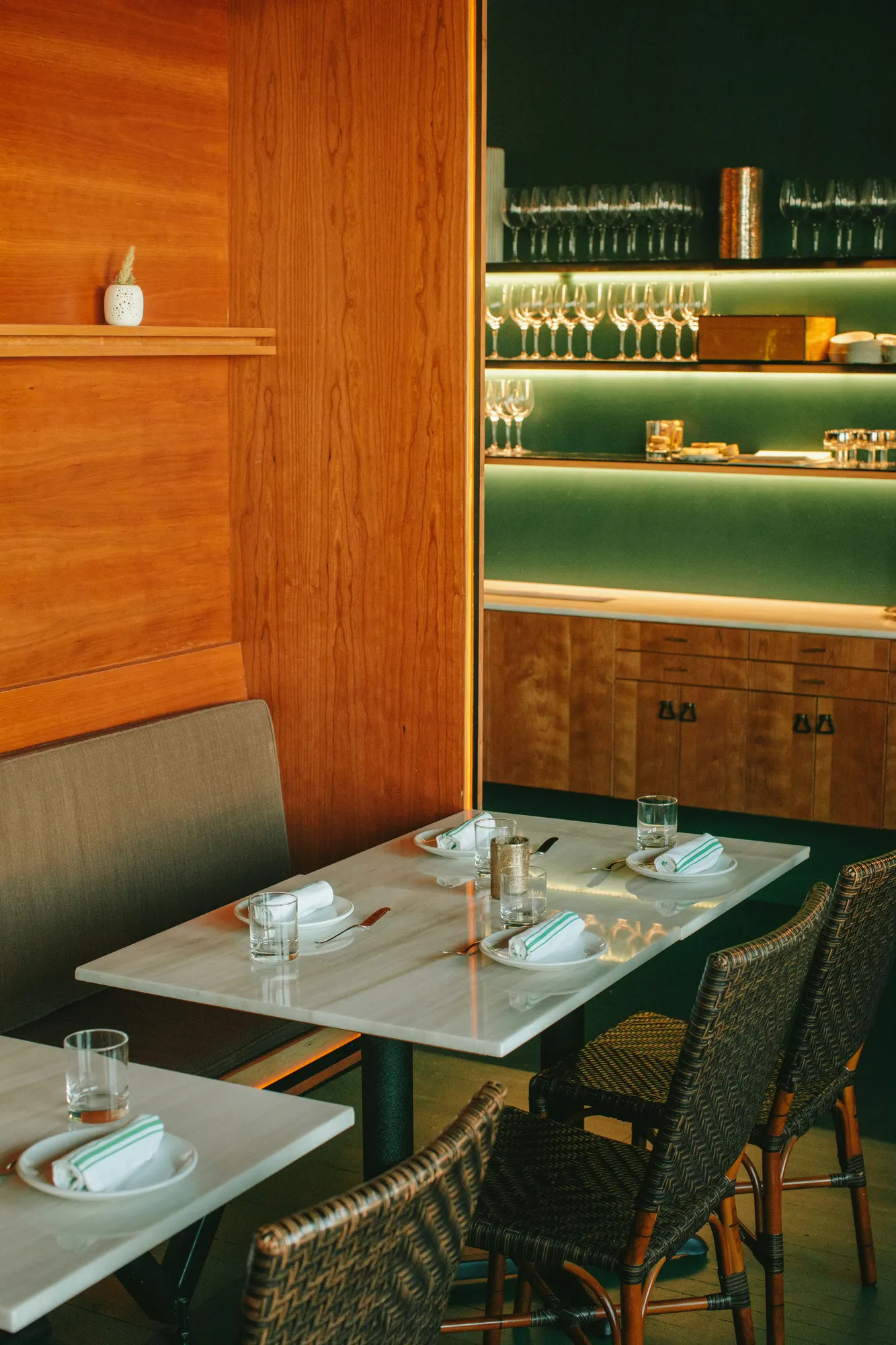 Marble tops against timber, with a lit shelf above the seat back.