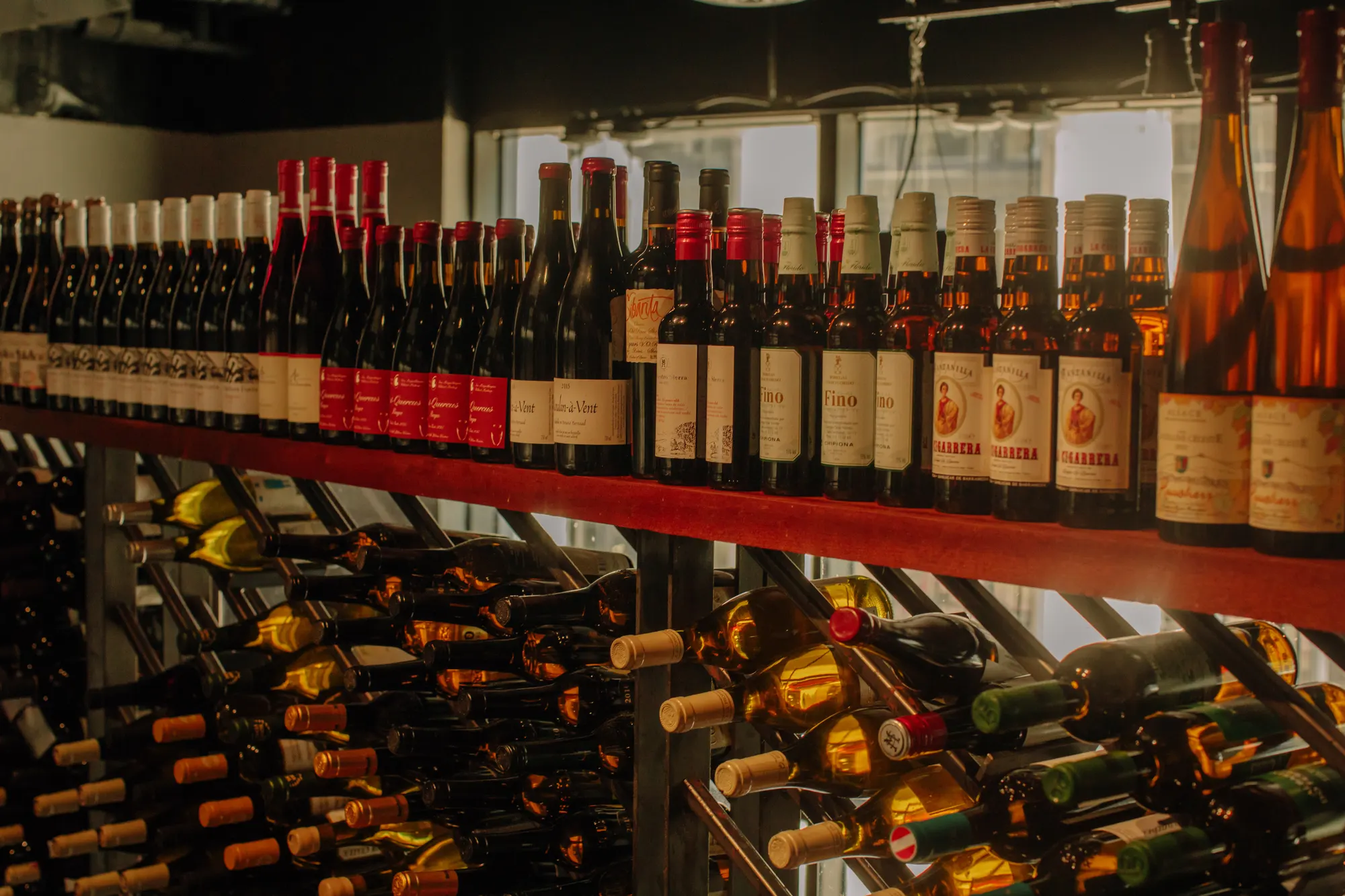 Bottles stood upright on the rail above the racks, so the label is what you read first.