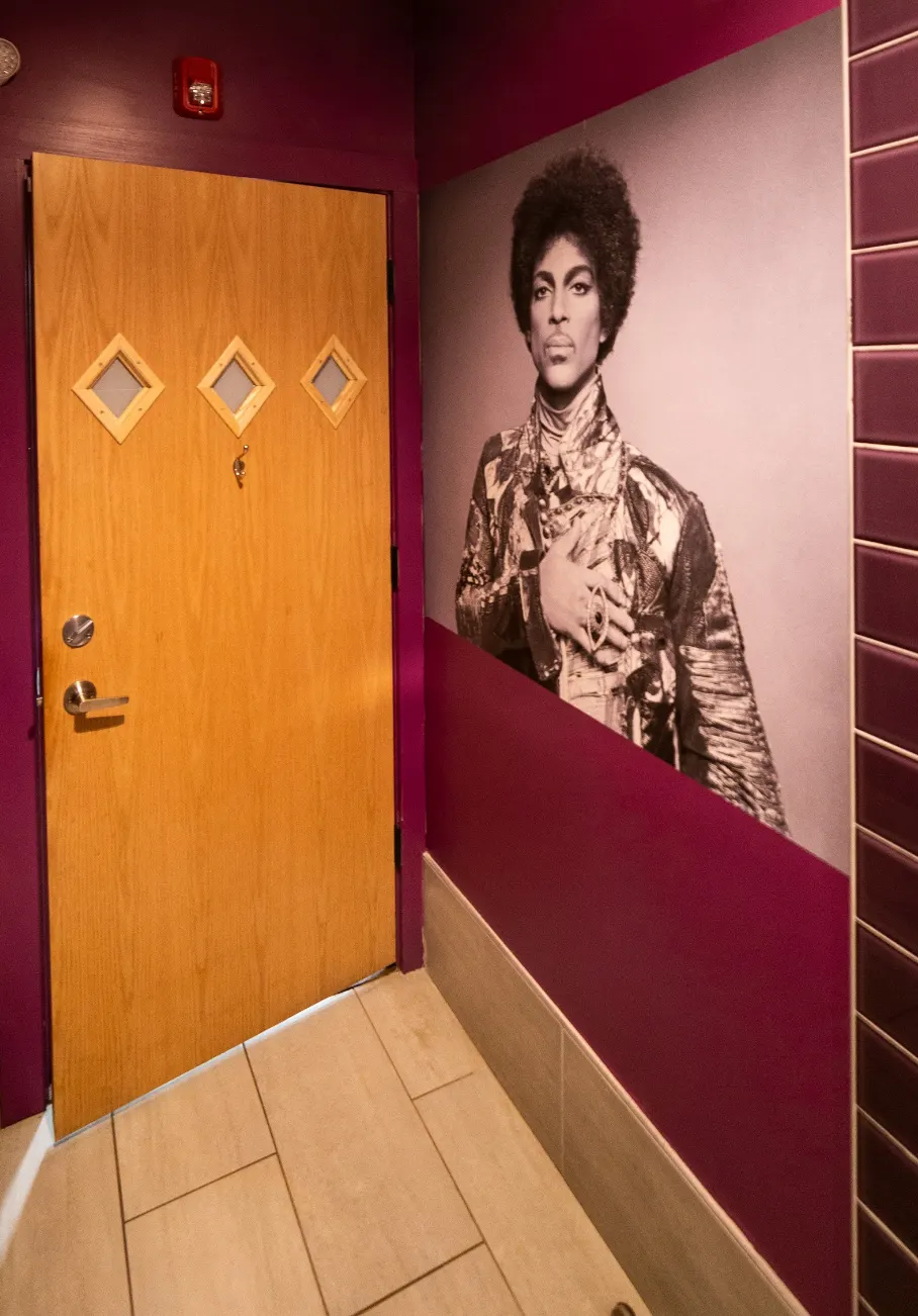 A timber door with diamond windows beside a large portrait photograph.
