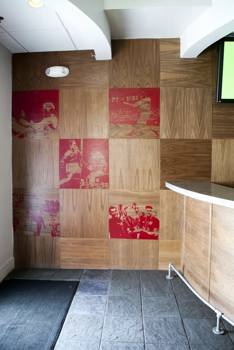 Timber panels printed in red with boxing photographs, beside the bar.