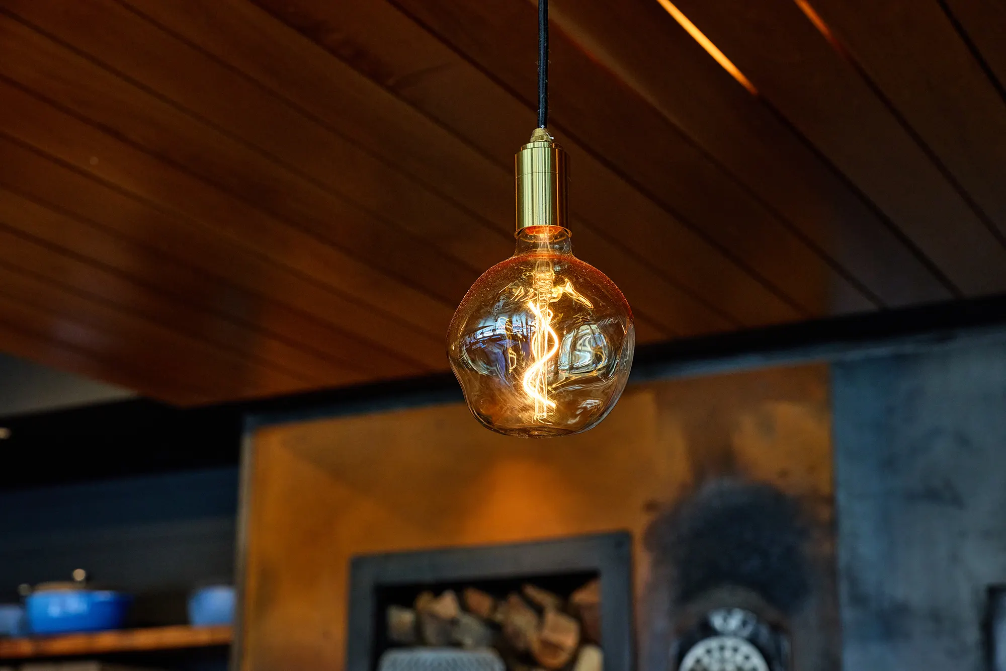 A glass globe bulb hanging under the timber ceiling.