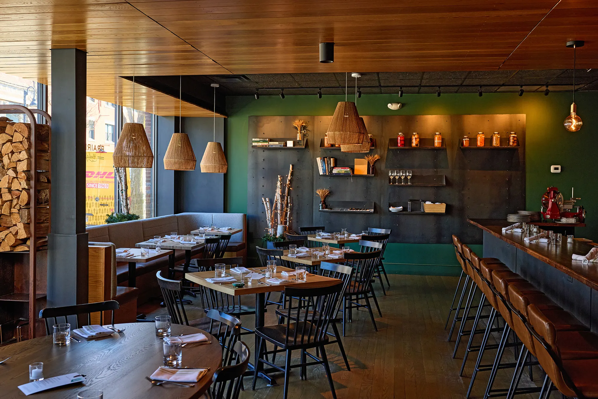 The dining room and the counter, with the shelving wall and woven pendants.