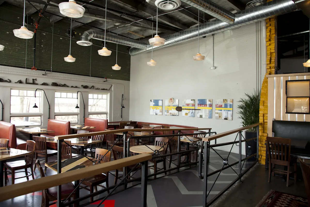 Banquettes along the wall, under pendants hung from the structure.