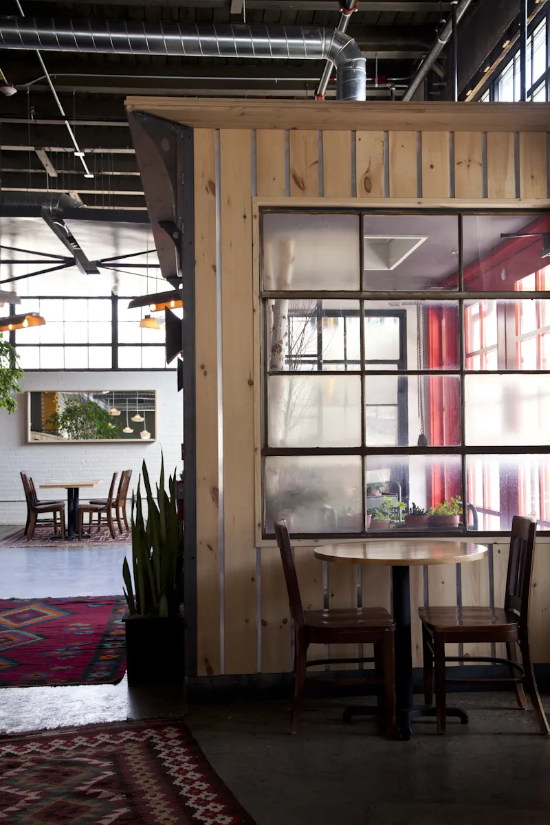A timber-clad room within the room, glazed so it keeps a view of the floor.