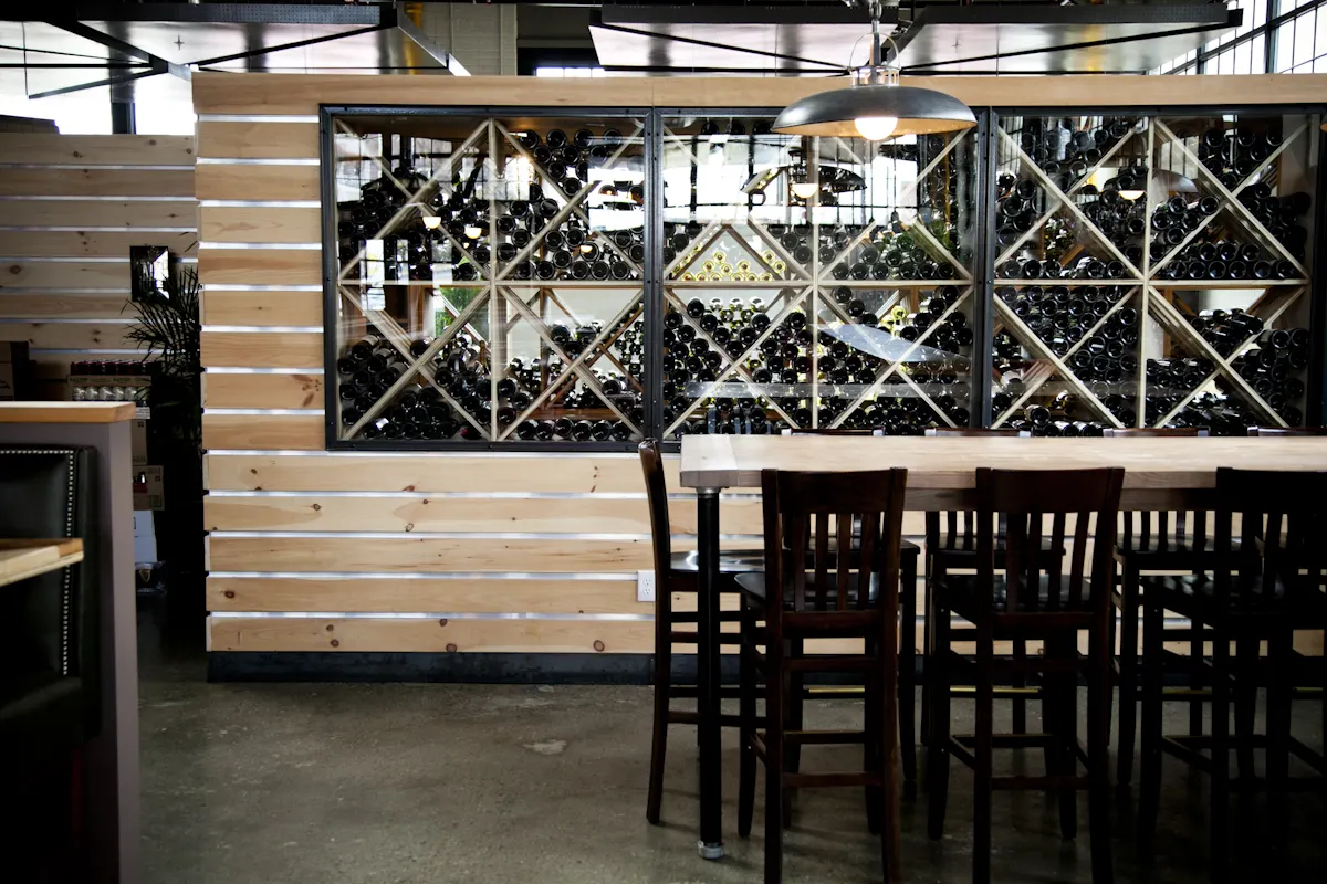 Tall tables and chairs against the wine store's glazed front.