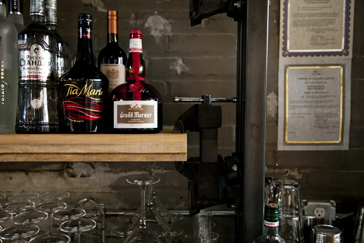 Bottles on a timber shelf against the old brick.
