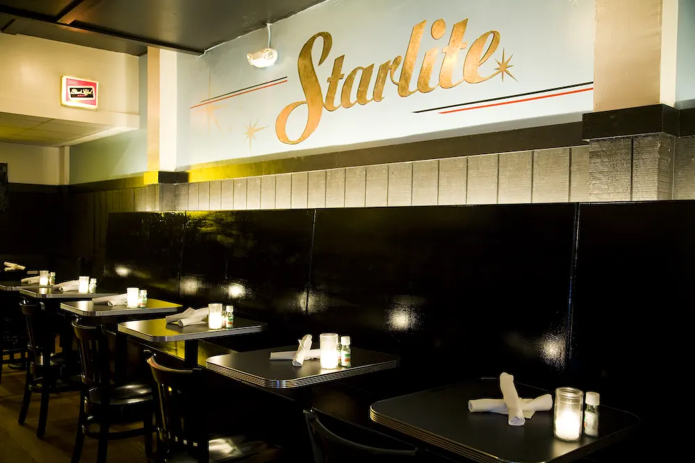 Trina's Starlite Lounge: tables and booths under a lit wall sign reading Starlite