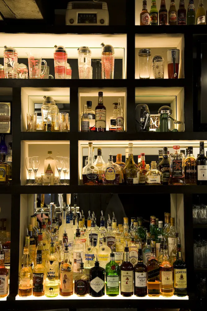 Lit shelves of spirits and glassware.