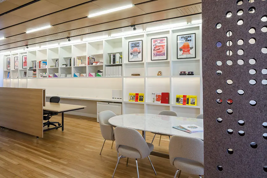 Posters on the shelves, a perforated screen at the end of the room.