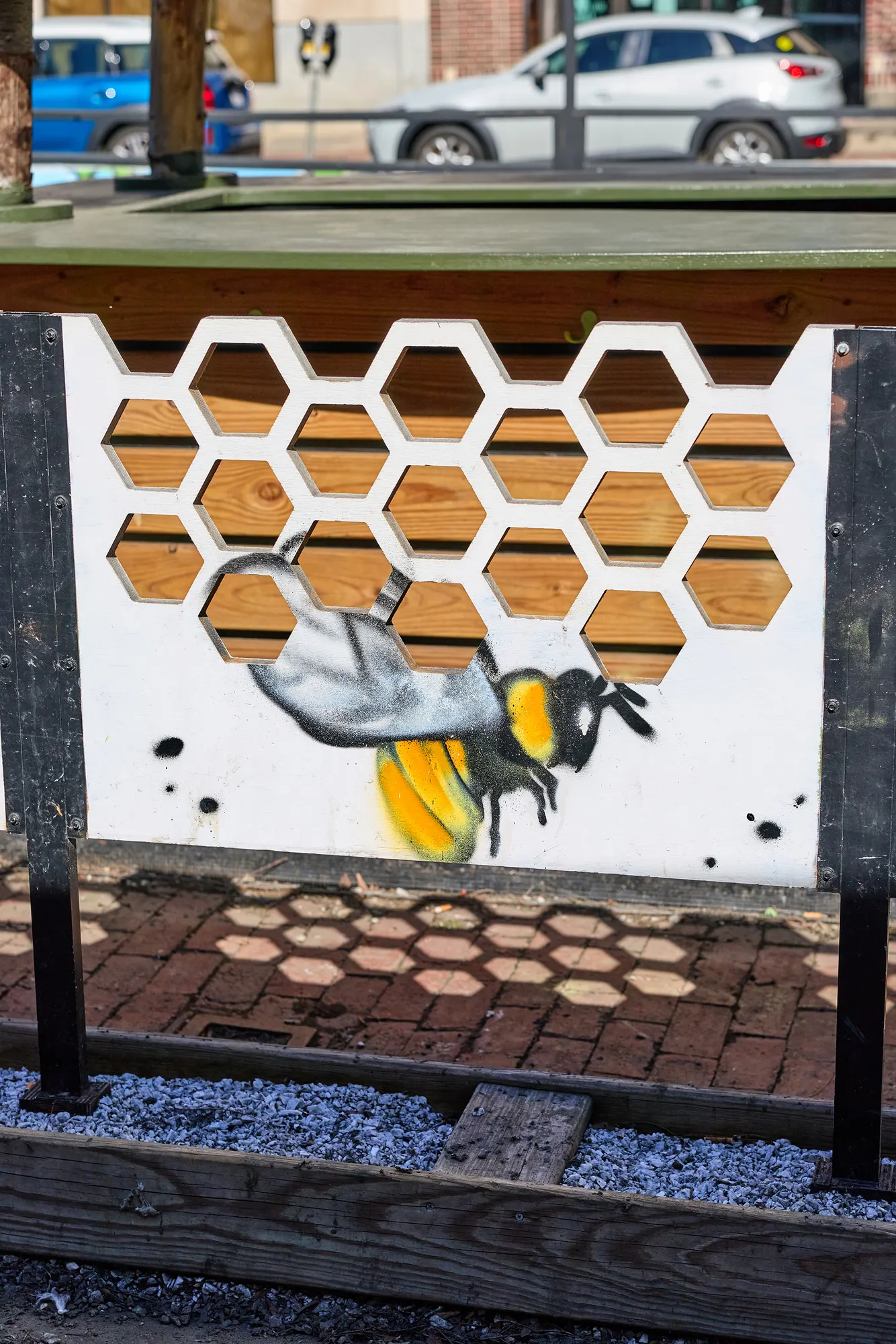 A painted bee crawling out of honeycomb openings.