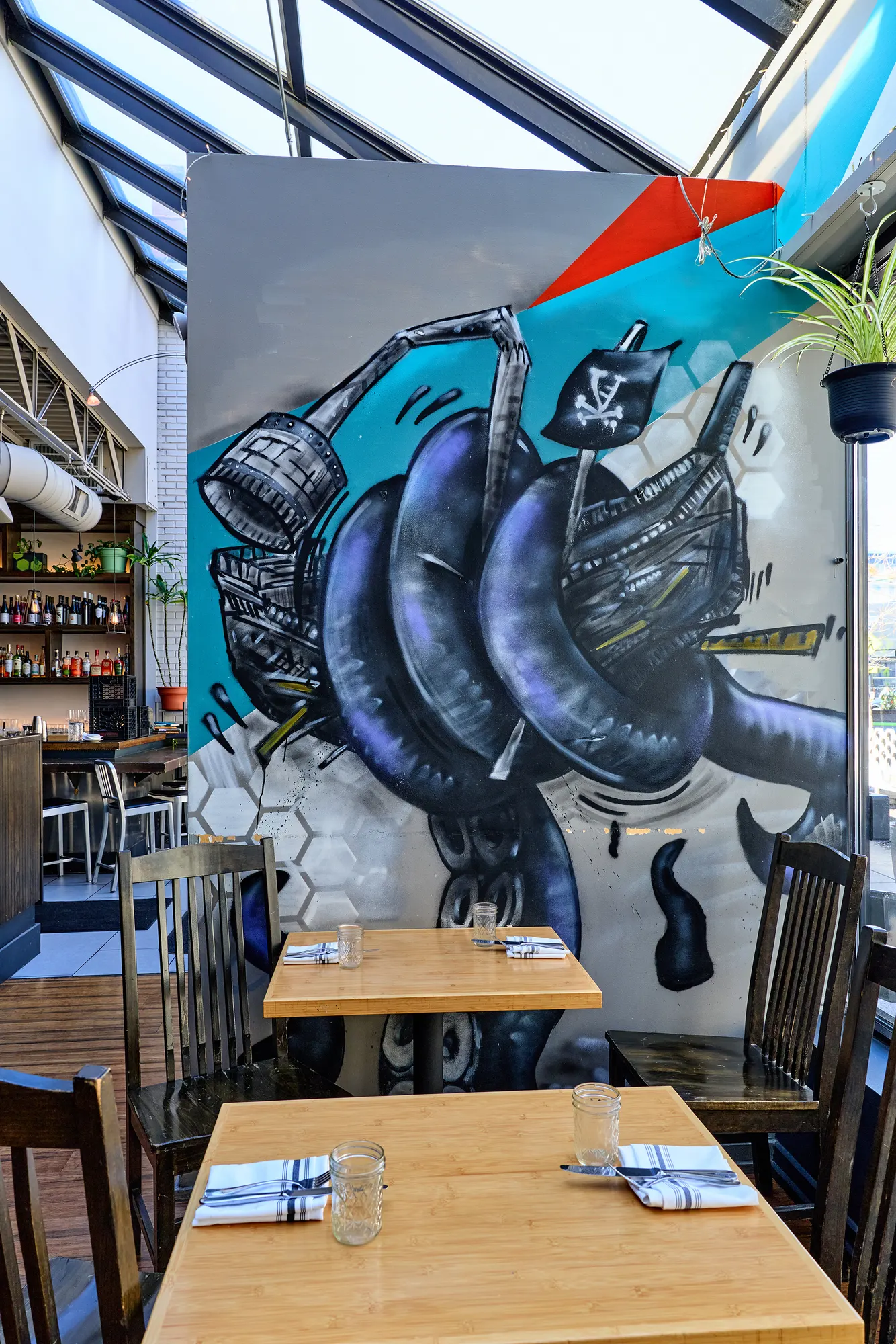 A large painted mural at the end of the room, over a table by the window.