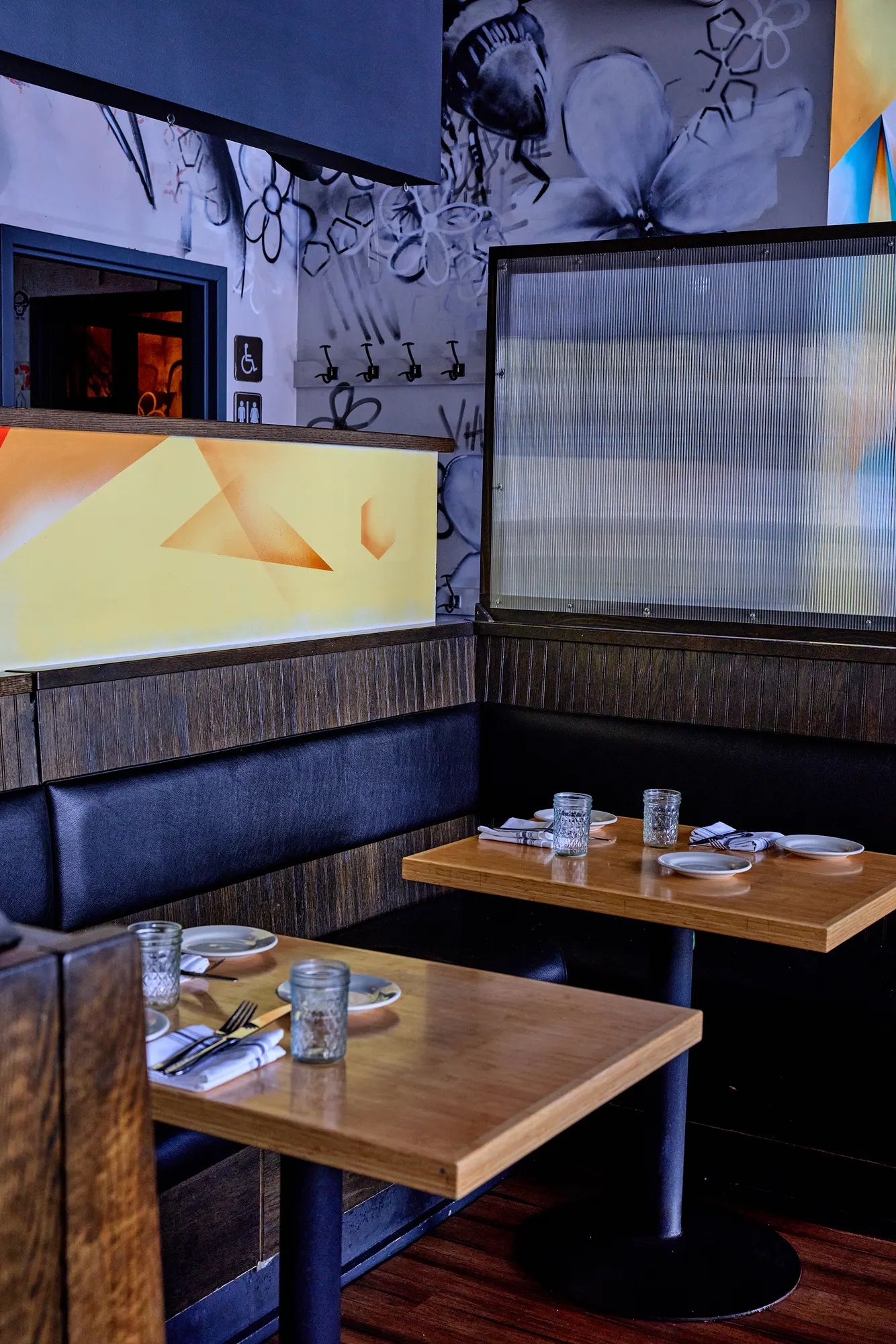 A booth corner with a painted wall and a frosted screen.