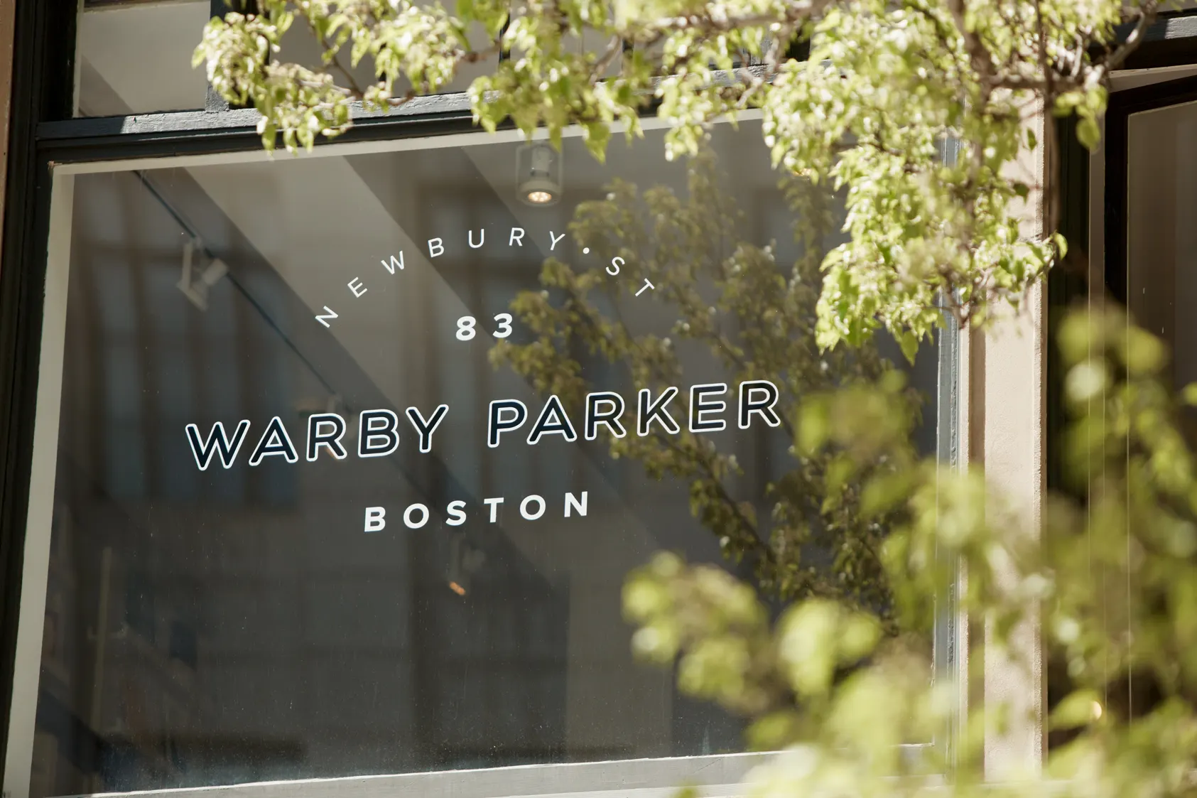The name set on the glass, with the street reflected in it.