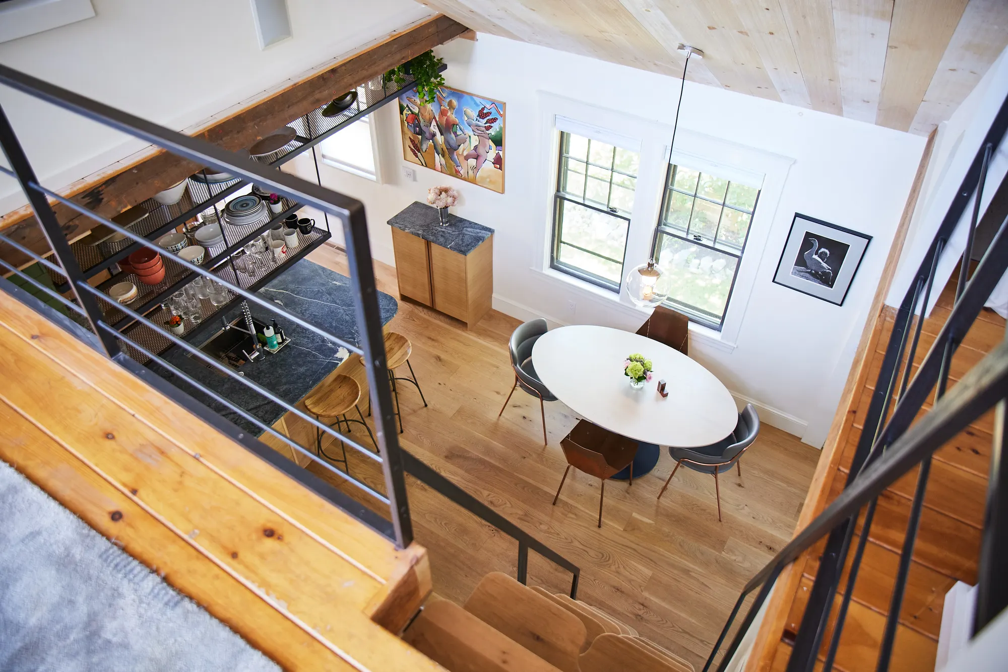 Looking down from the loft over the rail to the dining table and the kitchen.