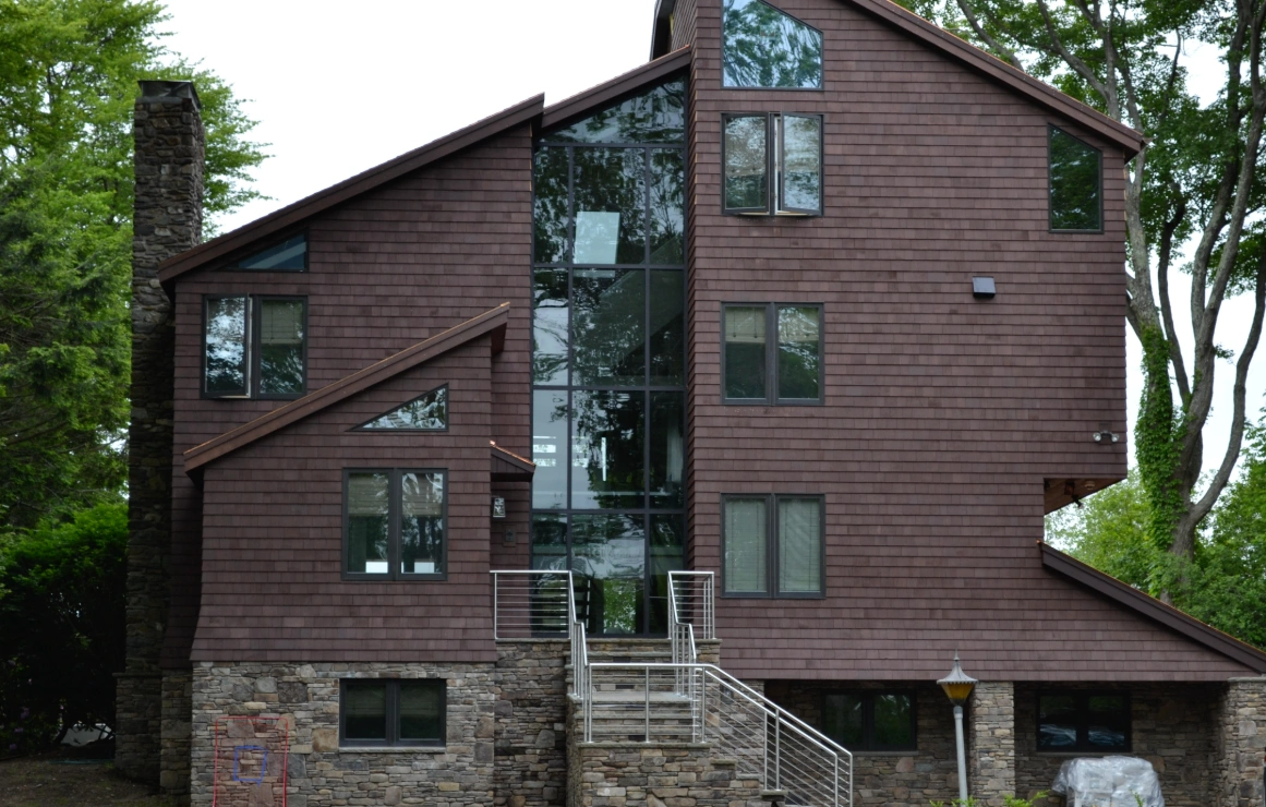 The Boch house, dark shingled gables around a full-height glazed stair tower