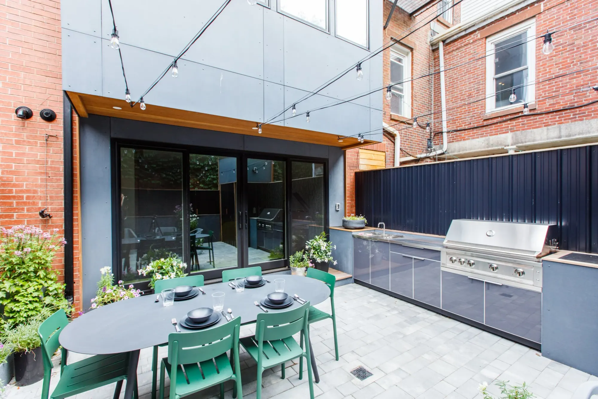 The back of the house glazed onto a walled patio, with an outdoor kitchen along one side.