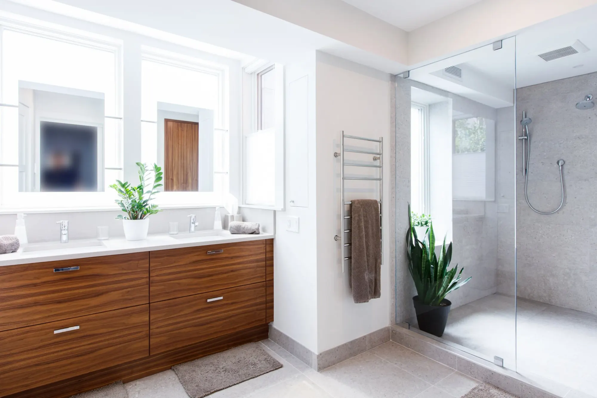 A walnut vanity beside a glass-walled shower.