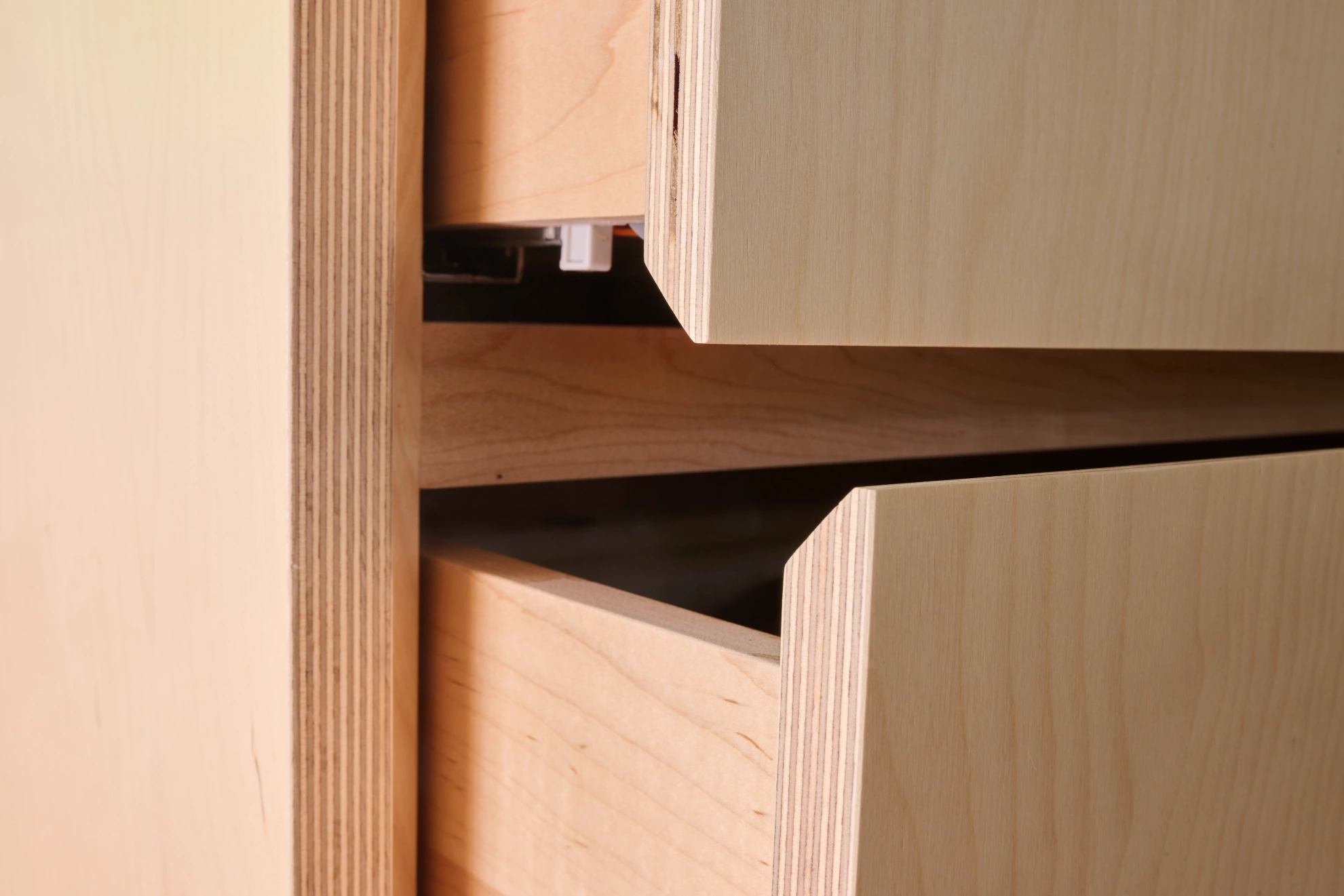 Birch-ply drawer fronts close up, their plywood edges left exposed.