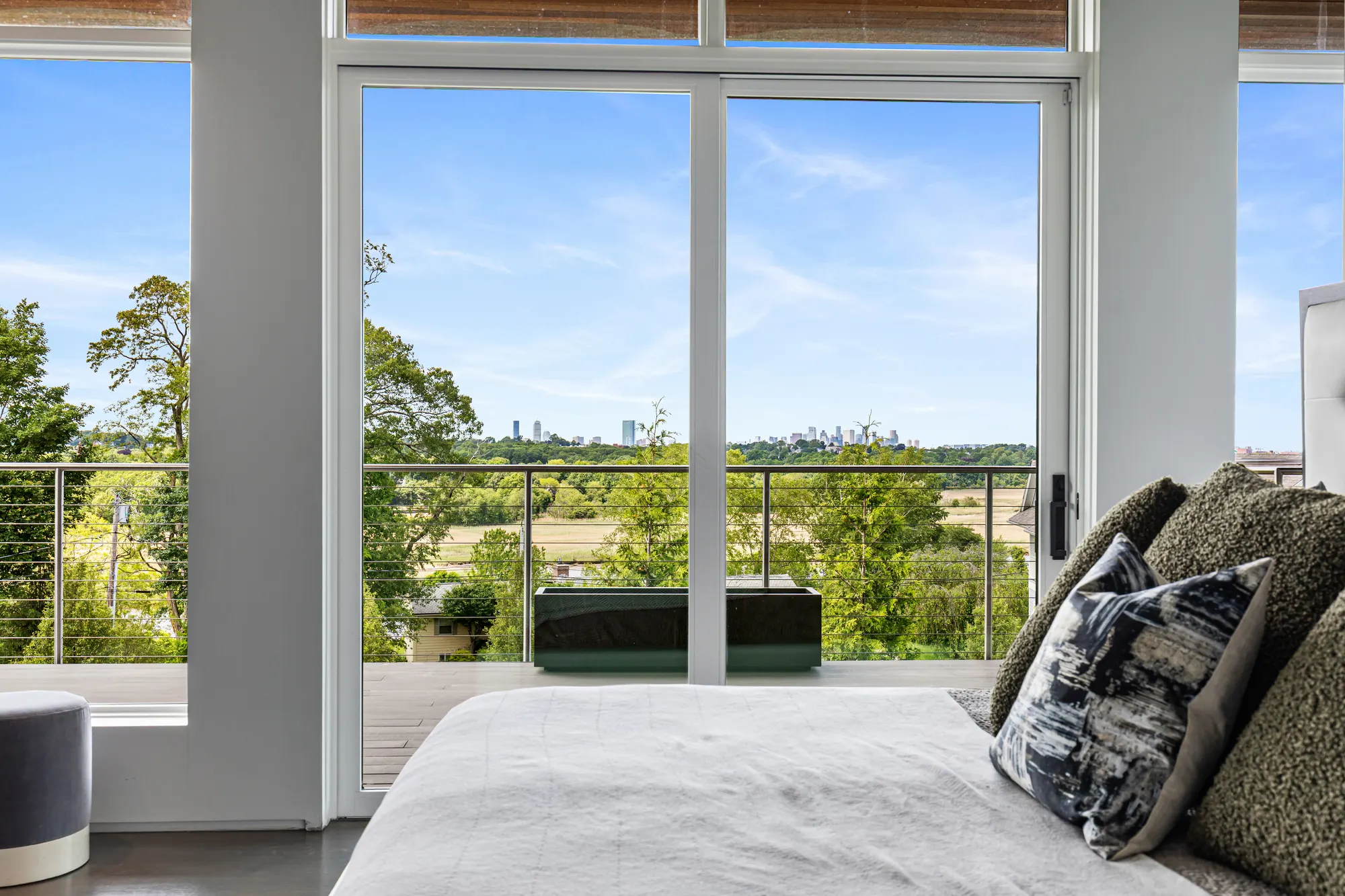 The view through the glass doors across the deck to the trees and the skyline.