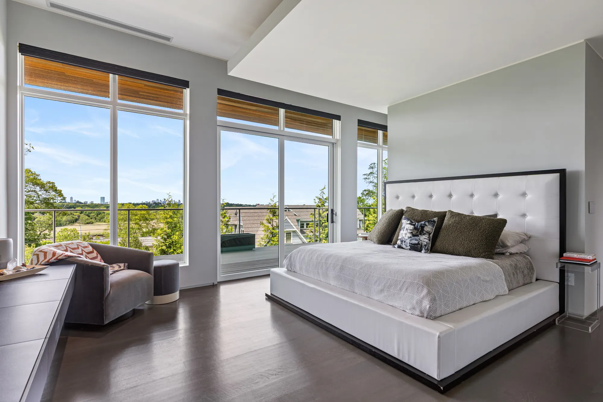 The bed, an armchair and the long window seat, with windows along two walls.