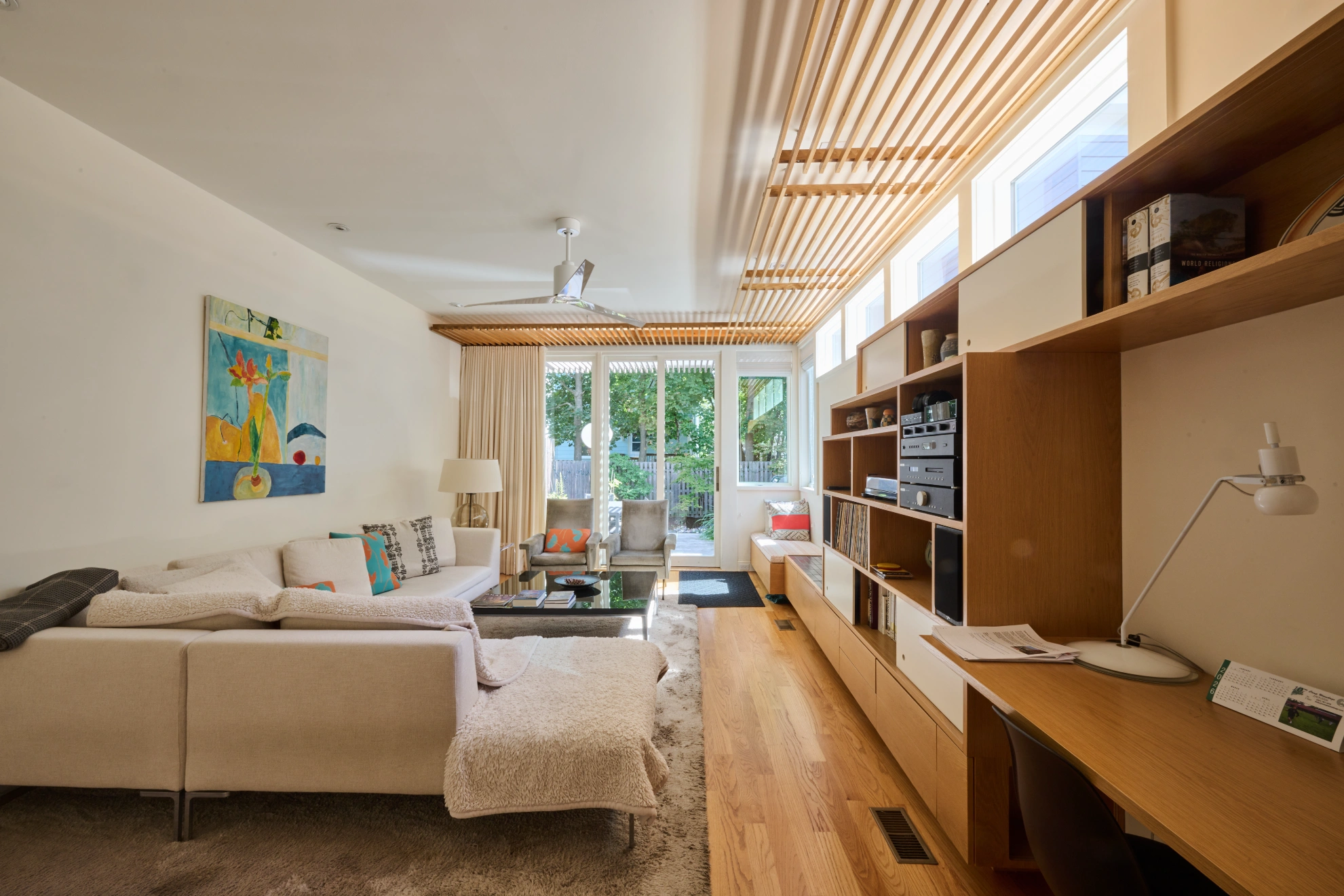 The living room looking toward glass doors onto the garden, with the built-in shelving along one side.